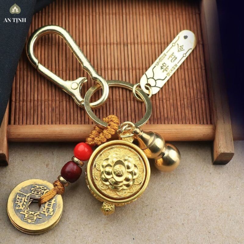Hạt ngọc đỏ trên dây móc của móc khóa Bát Tụ Bảo Xoay Phong Thủy