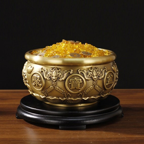 Ý nghĩa chính của bát tụ bảo xoay là chiêu tài lộc, may mắn và sự giàu có cho gia chủ. Thiết kế "nắp xoay" thường là một chi tiết hình thỏi vàng, có thể xoay được, nhằm tăng thêm yếu tố thu hút tài lộc.